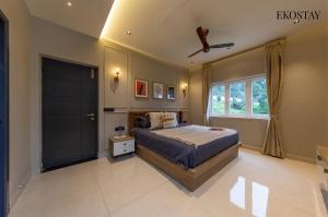 a bedroom with a bed and a ceiling fan at EKOSTAY - Amber Villa in Kodaikānāl