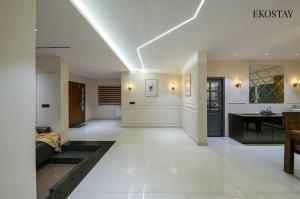 a living room with a white ceiling with lights at EKOSTAY - Amber Villa in Kodaikānāl