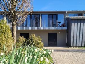 a house with a balcony with a tree and flowers at Hof Gasswies in Klettgau