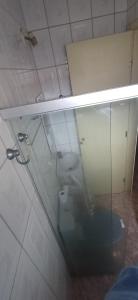 a bathroom with a toilet and a glass wall at Suite027 3p in Guarapari +4 photos