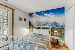 a bedroom with a bed with a painting on the wall at The Rikz Cabin in South Lake Tahoe