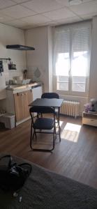 a kitchen with a table and a chair in a room at Le 105 BIS in Vichy
