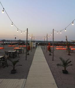a walkway with lights and tables and tables and chairs at La Mare Apartments - 25 in Constanţa