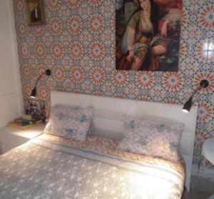 a bedroom with a bed with a picture on the wall at The 18, Marsa Guest House in Tunis