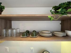 uma prateleira com pratos, copos e copos em Loft com vista para Vila Germânica 705 em Blumenau