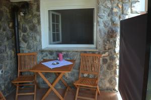 a table with two chairs and a television on a stone wall at Villa Dabac in Sveti Juraj