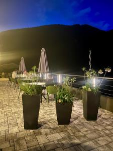 a patio with a table and chairs and plants at Hotel Aurora in Molveno