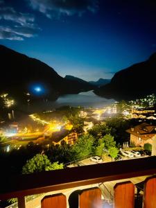 a view of a city and a lake at night at Hotel Aurora in Molveno