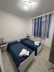 two beds in a bedroom with blue sheets and towels at Al' Rrigo in Bolsena