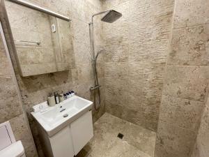 a bathroom with a shower and a sink and a toilet at 2BR central escape in Varna City