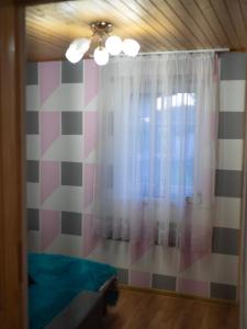 a room with a window with a curtain and a ceiling at Sodyba pas Babą - namas KLASIKA in Palanga