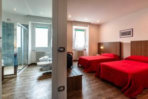 a hotel room with two beds and a bathroom at Hotel National in Zelbio