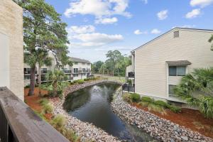 an apartment complex with a pond next to a building at Forest Beach Villa - 2 BDR for 6 in Hilton Head Island
