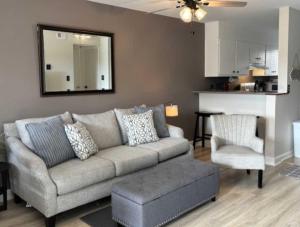 a living room with a gray couch and a mirror at Resort Condo for 6 with Tons of Amenities Near Beach in Hilton Head Island