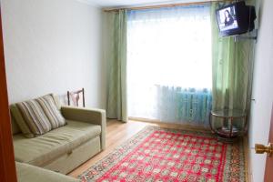 a living room with a couch and a large window at Ferrari Apartments in Vinnytsya