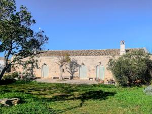 a large brick building with arched windows and a tree at Masseria PietraViva in Altamura