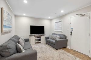 a living room with a couch and a flat screen tv at Ocean Breeze - Island Retreat for 6 in Hilton Head Island