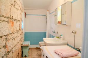 a bathroom with a white sink and a toilet at Masseria PietraViva in Altamura