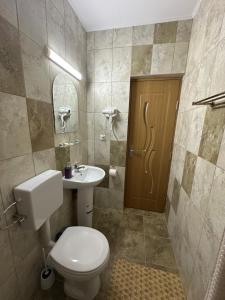 a bathroom with a toilet and a sink at Casa Militaru in Murighiol +5 photos