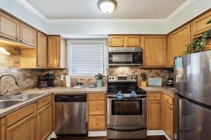 a kitchen with wooden cabinets and stainless steel appliances at Relaxing Condo for 6 in Popular Hilton Head Resort in Hilton Head Island