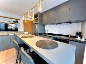 a kitchen with a counter with two sinks in it at Loft 413 Inn no Parque Una in Pelotas +11 photos