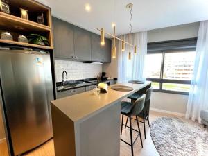 a kitchen with a stainless steel refrigerator and a counter at Loft 413 Inn no Parque Una in Pelotas