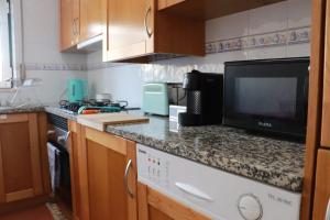 a kitchen with a counter with a tv and a dishwasher at Fantastic apartment with pool access in Pataias