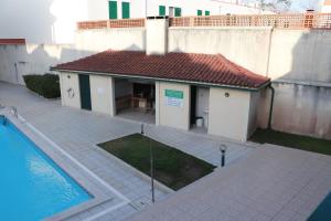 a small building next to a swimming pool at Fantastic apartment with pool access in Pataias