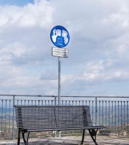 a bench in front of a fence with a sign at Mavianto in Torre le Nocelle