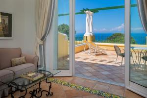 a living room with a couch and a view of the ocean at Hotel Caesar Augustus in Anacapri