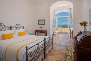 a bedroom with a bed and a view of the ocean at Hotel Caesar Augustus in Anacapri