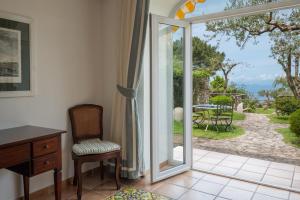 a room with a door open to a patio with a table at Hotel Caesar Augustus in Anacapri