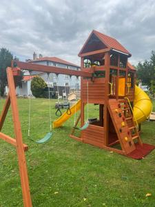a wooden play set with a slide and a playground at Domaine du Rosiere in Favières