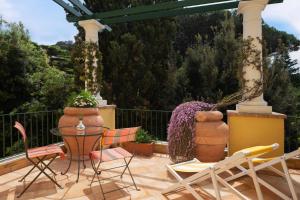 a patio with a table and chairs and plants at Hotel Caesar Augustus in Anacapri
