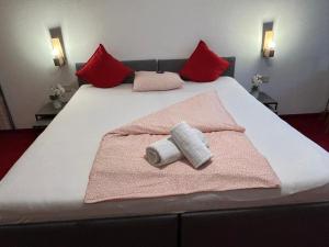 een bed met twee handdoeken en rode kussens erop bij Comfort Room in Warmbad in Villach