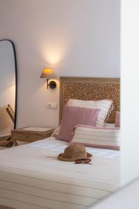 a bedroom with a bed with a hat on it at Hotel Rosamar - Emar Hotels in Es Pujols