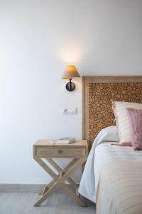 a bed and a table with a lamp on a side table at Hotel Rosamar - Emar Hotels in Es Pujols