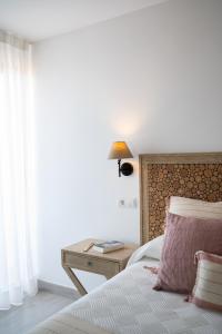 a bedroom with a bed and a table with a lamp at Hotel Rosamar - Emar Hotels in Es Pujols