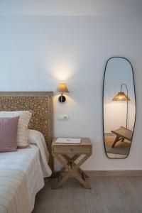 a bedroom with a mirror and a bed and a table at Hotel Rosamar - Emar Hotels in Es Pujols