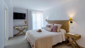 a bedroom with a bed with a cat sitting on it at Hotel Rosamar - Emar Hotels in Es Pujols