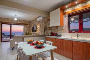 a kitchen with a table with a bowl of fruit on it at Arca Villa - Enchanting Sunset! in Keri