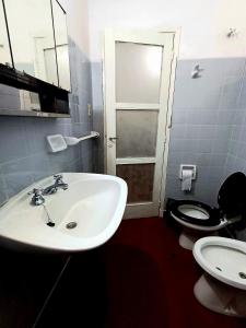 a bathroom with a white sink and a toilet at Casa Chalet 6 personas in Cosquín