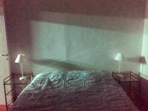 a bedroom with a bed with two lamps on it at Casa Chalet 6 personas in Cosquín