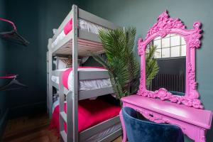 a pink bunk bed with a mirror and a chair at Vibrant 2-Bedroom Chapel Retreat in Barnard Castle
