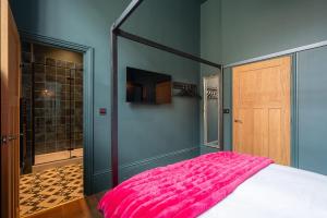 a bedroom with a pink bed and a mirror at Vibrant 2-Bedroom Chapel Retreat in Barnard Castle +11 photos