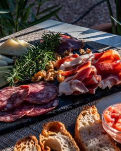 a tray of food with meats and bread on a table at Hotel Rosamar - Emar Hotels in Es Pujols