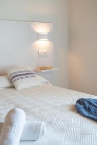a bedroom with a white bed with a light on it at Hotel Rosamar - Emar Hotels in Es Pujols +37 photos