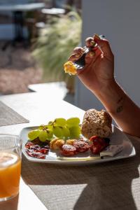 a person eating food on a plate with a plate of food at Hotel Rosamar - Emar Hotels in Es Pujols