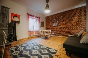 un salon avec un canapé et un mur de briques dans l'établissement Off Piotrkowska Spot, à Łódź 2 autres photos