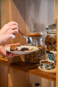a person holding a plate of food on a shelf at Hotel Rosamar - Emar Hotels in Es Pujols